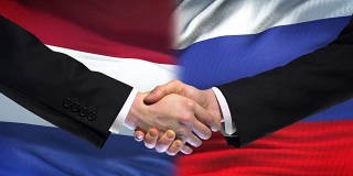 荷兰和俄罗斯握手，国际友谊，旗帜背景