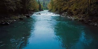 低空飞过山河，蓝色的森林和群山中间。日落时间。太阳光发出橙色的光斑。治疗泌尿系统疾病和前列腺炎的概念